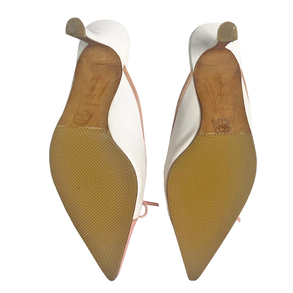 Chanel CC logo cap toe mules by Karl Lagerfeld for Chanel circa early 2000’s. White leather with pink pointed toe cap featuring tonal stitched interlocking CC logo with pink grosgrain edging and pink leather front bow. Leather upper, heels and sole. Made in Italy