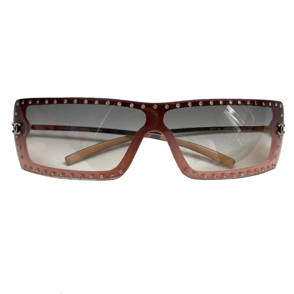 Chanel Pink Shield Frame with Crystal Sunglasses with curved rectangular shield frame and silver-tone metal arms. Swarovski crystals surround the lens with silver-tone interlocking CC logo on each side and CHANEL engraved arms. Color: Pink frame, Grey gradient lens. Made in Italy