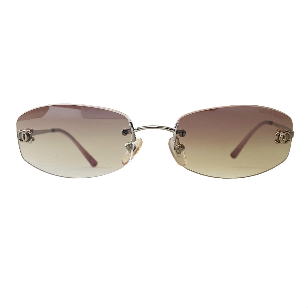 Chanel gradient lens rimless CC Logo sunglasses rounded rectangular shaped gradient pink rimless lenses with silver-tone CC logo on each lens. Silver-tone arms with purple ear piece Style: 4002 c124/58 Case included. Made in Italy.