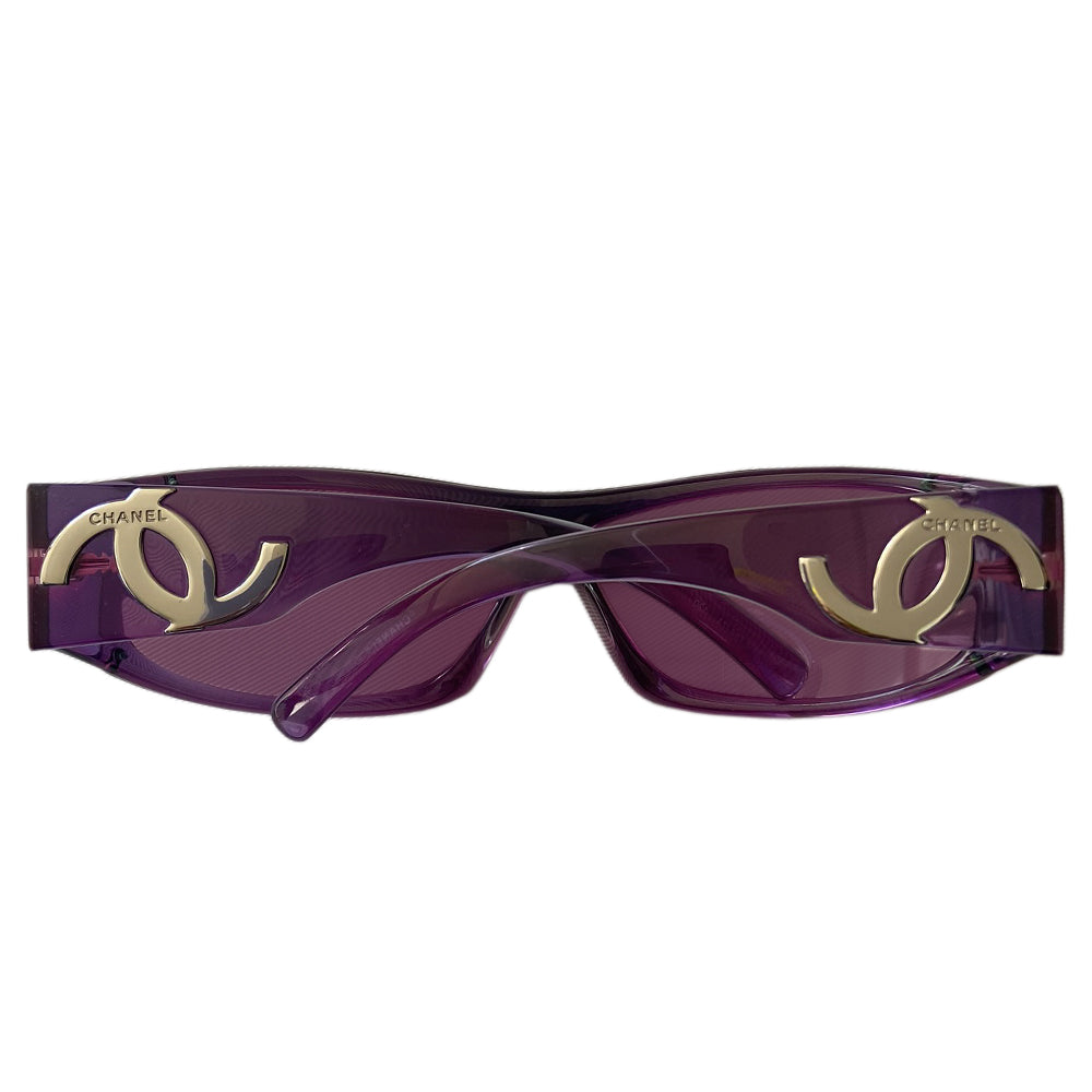 Chanel purple wrap CC logo sunglasses by Karl Lagerfeld for Chanel with frameless lens with wide purple arms and silver-tone asymmetric CC logo at temples. Style: 5072 Made in Italy