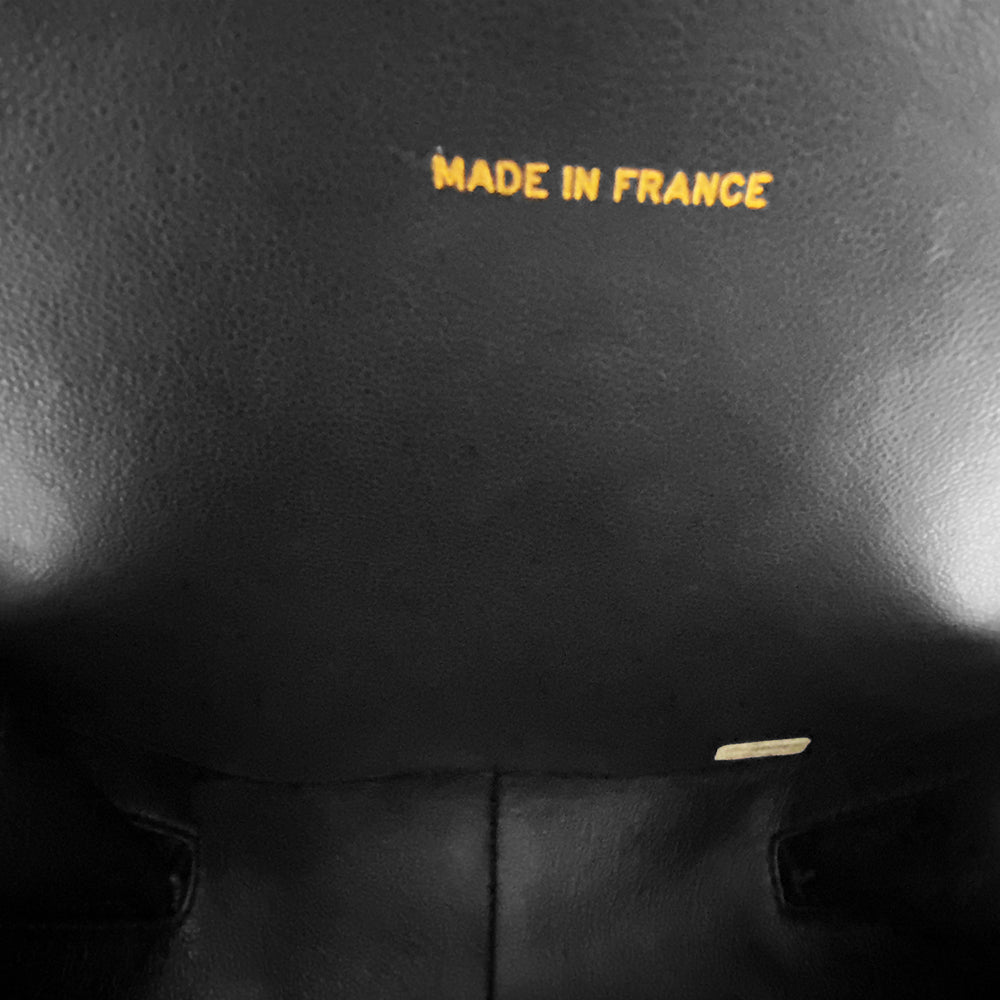 Chanel round diamond quilted black patent vanity case by Karl Lagerfeld for Chanel 1994-1996 with white interlocking appliqué CC logo at front, interwoven leather and gold chain top handle. Dual gold-tone zip around closure open to black leather interior with single slip pocket. Made in France