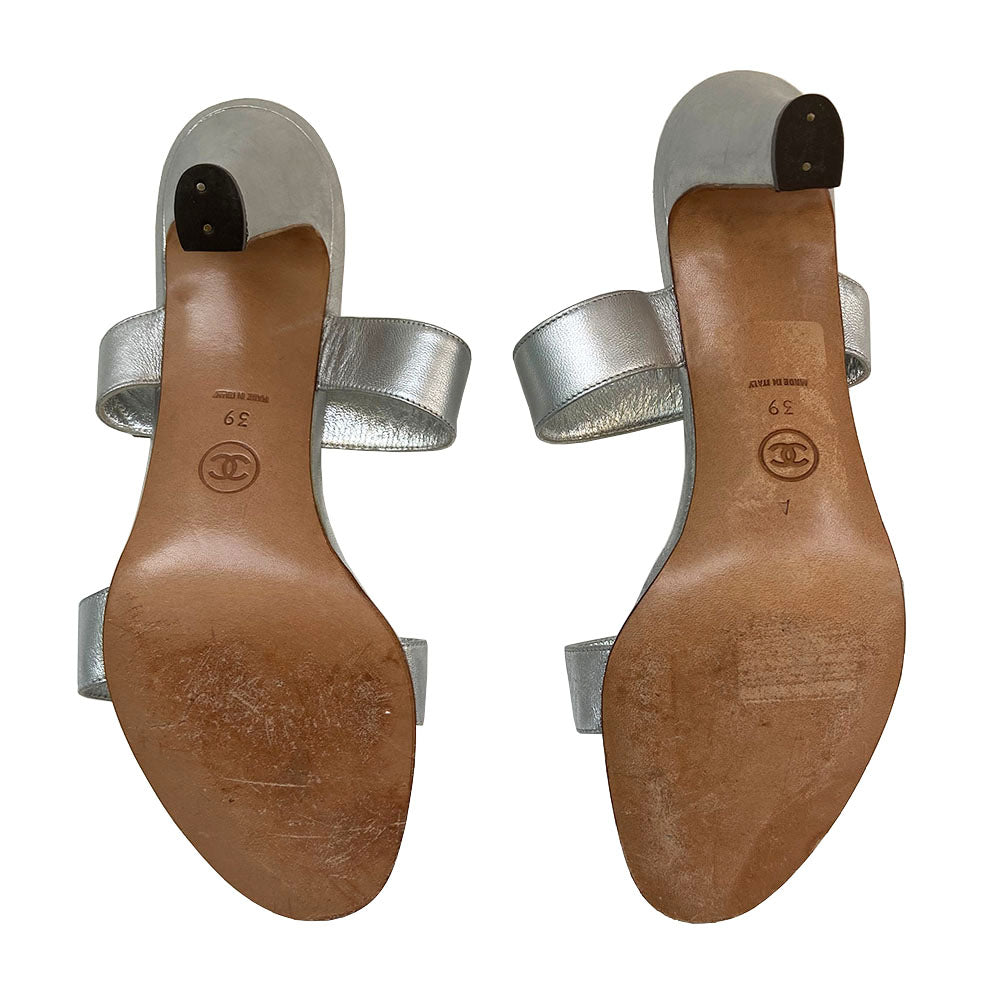 Chanel silver metallic leather open-toe heeled sandals, slip on style with 2 strap upper with silver-tone signature Chanel Mademoiselle turn-lock CC logo embellishment on one strap. Leather interior and soles. Almost no wear at soles Size: IT 39 Made in Italy