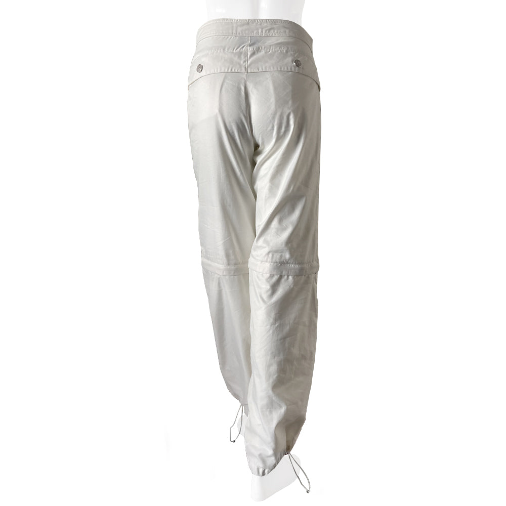 Chanel Identification white sport pants from 2001. High waisted with banded side slash pockets and back flap pockets with silver CC logo snap. Rubber identification silver and white logo at waist. Chanel logo metal toggles cinch the bottom hem. Zipper at knee removes lower leg convertible to shorts. Made in Italy