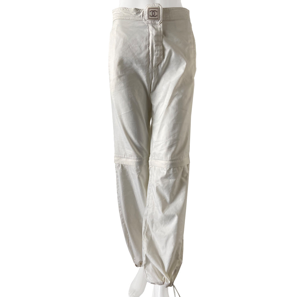 Chanel Identification white sport pants from 2001. High waisted with banded side slash pockets and back flap pockets with silver CC logo snap. Rubber identification silver and white logo at waist. Chanel logo metal toggles cinch the bottom hem. Zipper at knee removes lower leg convertible to shorts. Made in Italy