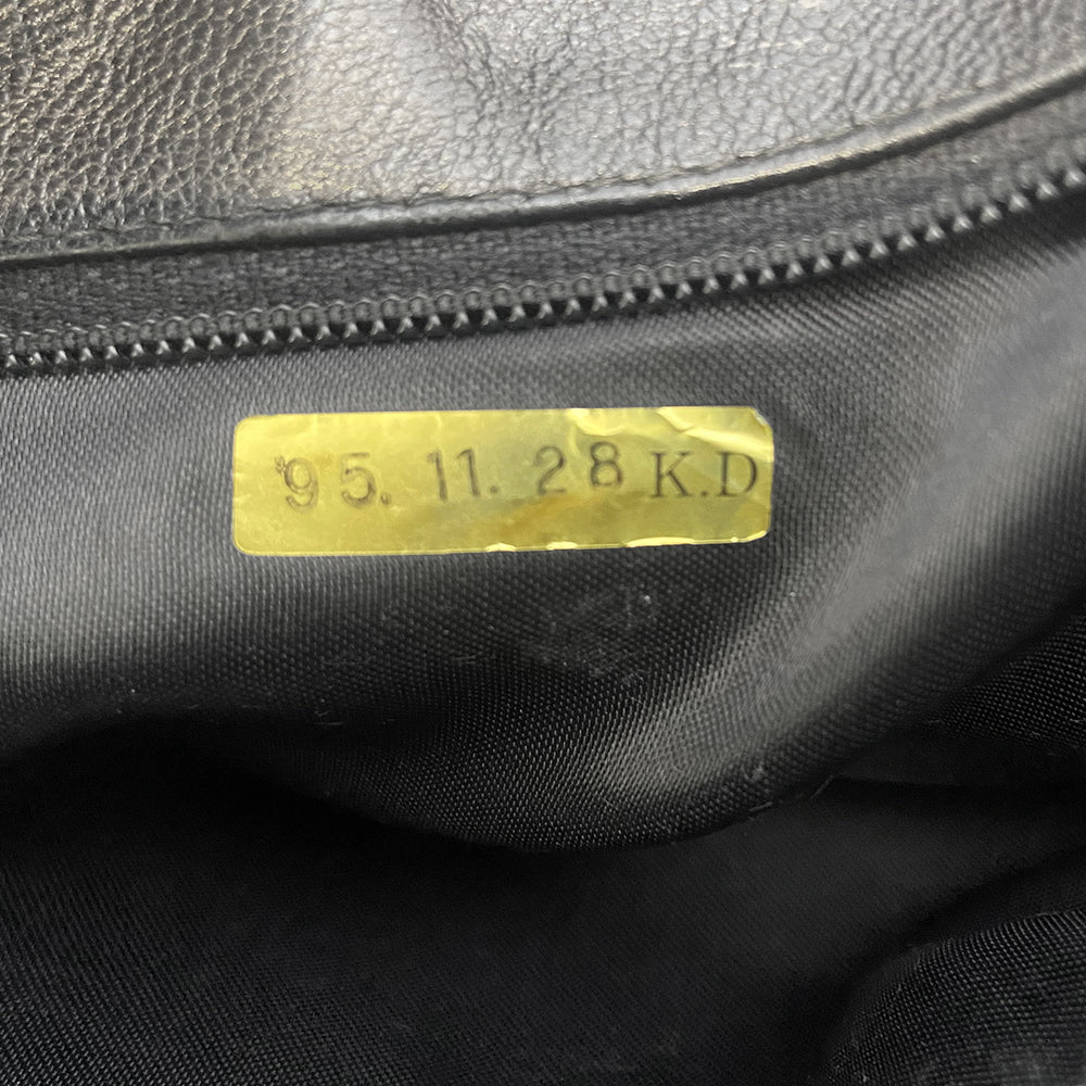Chanel quilted CC logo crossbody charcoal grey shoulder bag with suede strap by Karl Lagerfeld for Chanel, 1995 with etched gold ball and tassels zipper pull, outer flap pocket with black leather lining, interior zippered pocket. Made in France