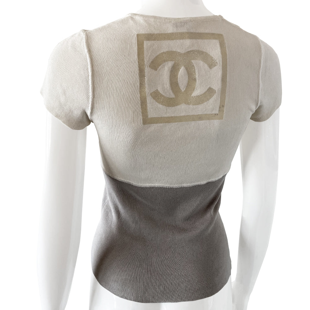 Chanel Logo Short Sleeve Knit top by Karl Lagerfeld for Chanel Spring 2001. Short sleeved two-tone color block fine rib knit with rounded ribbed edge neckline and larger ribbing at sleeves Interlocking box CC logo centered at upper back. 100% cotton in cream/grey Size: FR 36