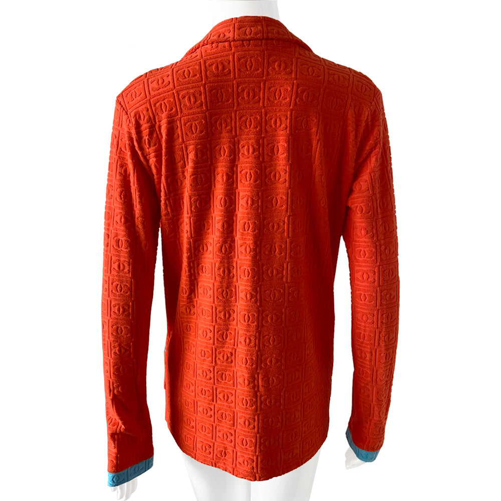 Chanel monogram terrycloth blazer by Karl Lagerfeld for Chanel S/S 2002 with long sleeves, all over boxed CC logo pattern, notched lapel, single logo silver-tone front snap button closure and 2 front patch pockets. Tangerine orange with turquoise accent. Made in France