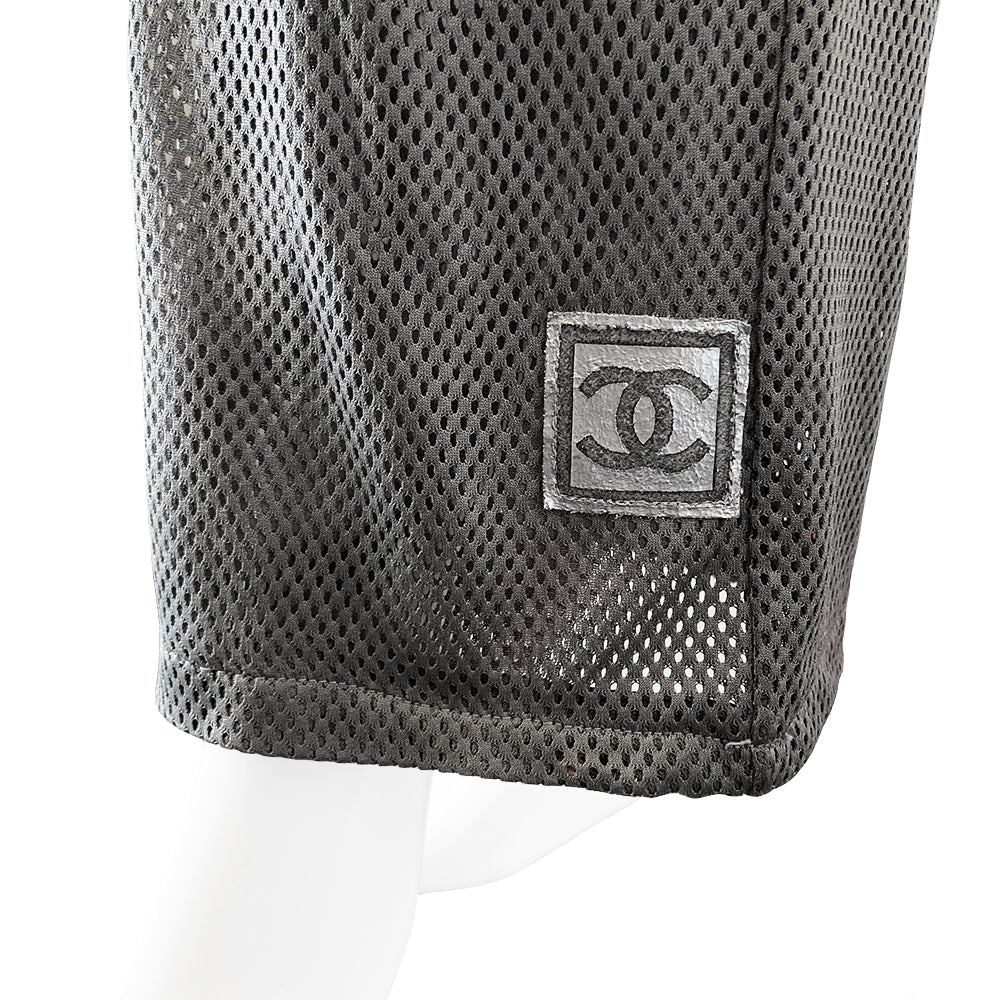 Chanel grey mesh drawstring pants with side frill from Spring 2003. High waisted wide leg pants made from see through double layered mesh with side zip pockets. Drawstring with CC logo engraved brushed silver-tone metal ends. Frill accent from waist to bottom hemline with Box CC logo at lower left leg. Made in Italy