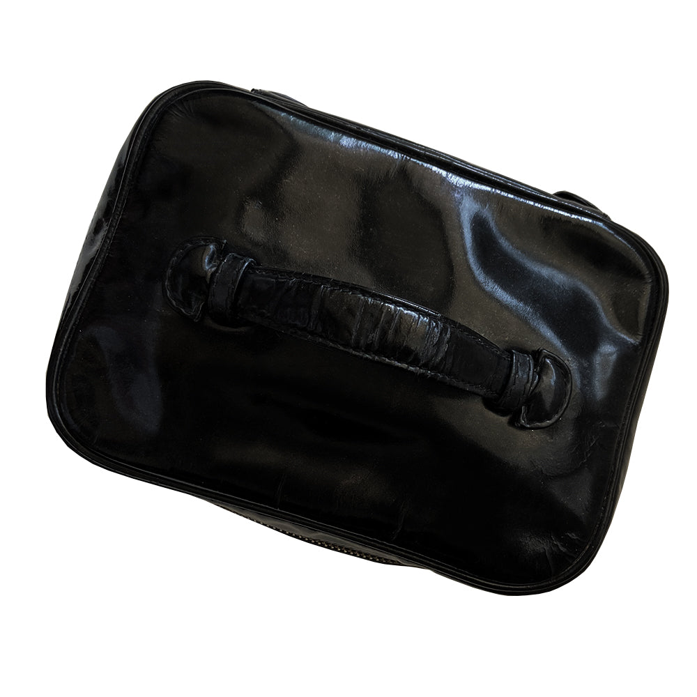 Chanel black patent leather vanity case by Karl Lagerfeld for Chanel 1996-1997 Rectangular bag with stitched interlocking CC logo at front, top handle, zip around closure with leather disc zipper pull embellished with gold CC logo. Leather interior with inner slip pocket pouch, Chanel stamped inside. Made in Italy