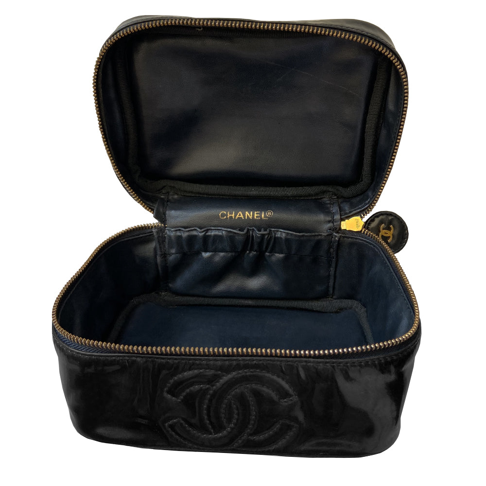 Chanel black patent leather vanity case by Karl Lagerfeld for Chanel 1996-1997 Rectangular bag with stitched interlocking CC logo at front, top handle, zip around closure with leather disc zipper pull embellished with gold CC logo. Leather interior with inner slip pocket pouch, Chanel stamped inside. Made in Italy