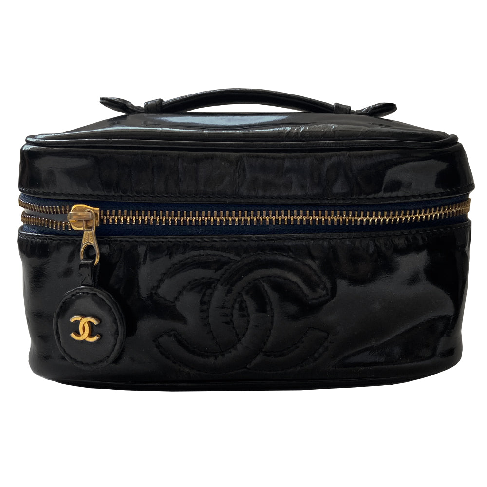 Chanel black patent leather vanity case by Karl Lagerfeld for Chanel 1996-1997 Rectangular bag with stitched interlocking CC logo at front, top handle, zip around closure with leather disc zipper pull embellished with gold CC logo. Leather interior with inner slip pocket pouch, Chanel stamped inside. Made in Italy