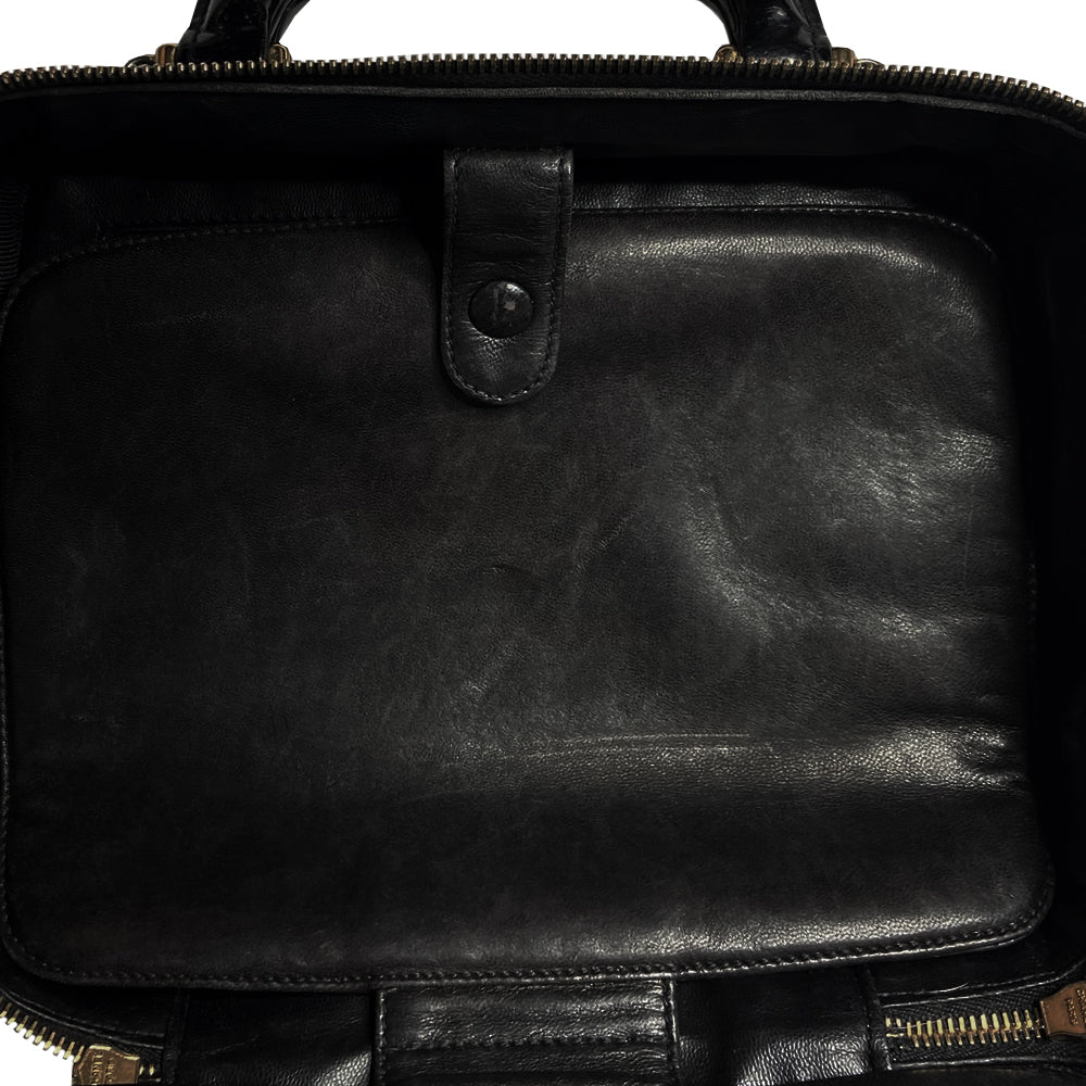 Chanel patent leather vanity case by Karl Lagerfeld for Chanel 1996 with interlocking CC logo at front, dual logo zipper pull closure, top carry handle and removable long strap. Leather interior with inner flap that snaps to side, zippered pocket with logo zipper pull, serial number sticker attached. Made in Italy