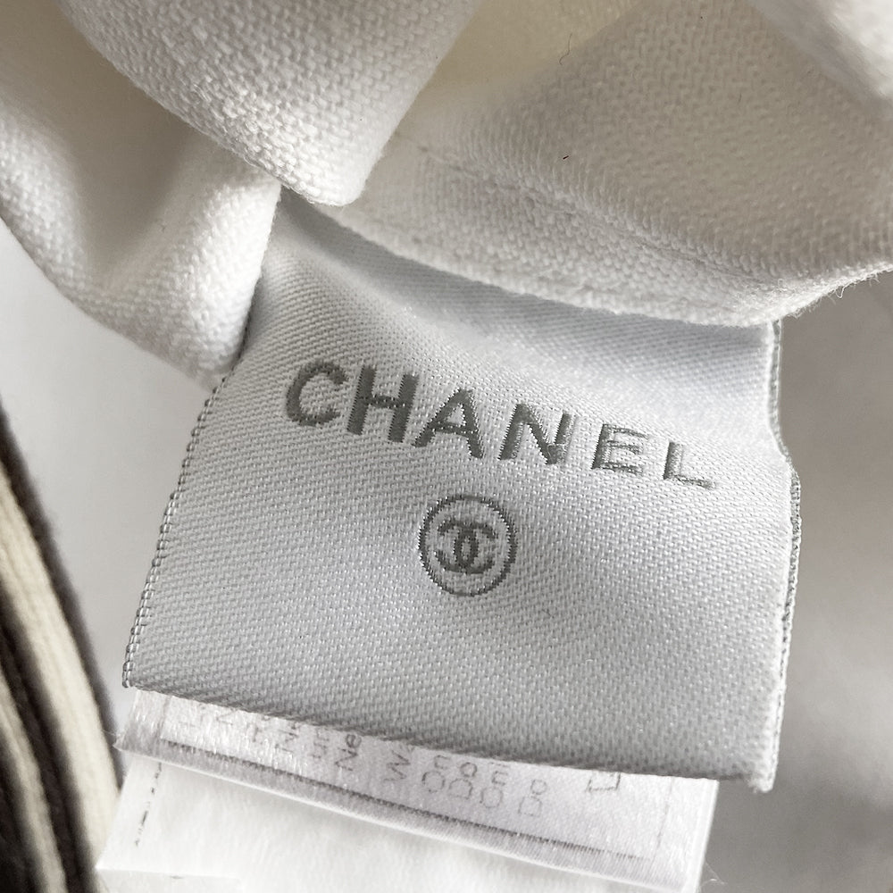 Chanel CC logo white canvas zip jacket by Karl Lagerfeld for Chanel, Cruise 2005 with accent stitching, brown and white striped knit accents, vented detail at sleeve hems. White CC logo zipper pull and white rubber box CC logo appliqué on arm. 100% Cotton