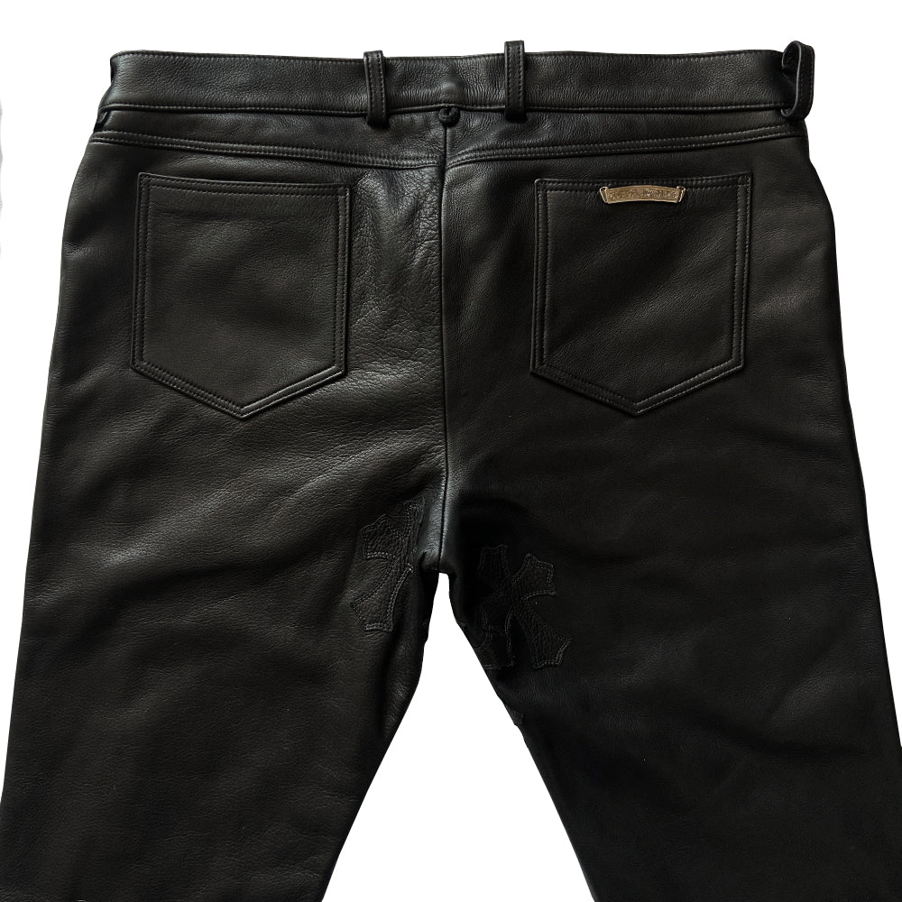 Custom-made unused black leather pants by Chrome Hearts, Los Angeles Front CH appliqué fleur du lis patch at front knees. 5 cross patches, Chrome Hearts jacquard silk lining, 5 sterling silver fly buttons. Three front pockets with sterling grommets, back pocket with sterling Chrome Hearts banner, Interior leather Chrome Hearts USA banner embossed patch.
