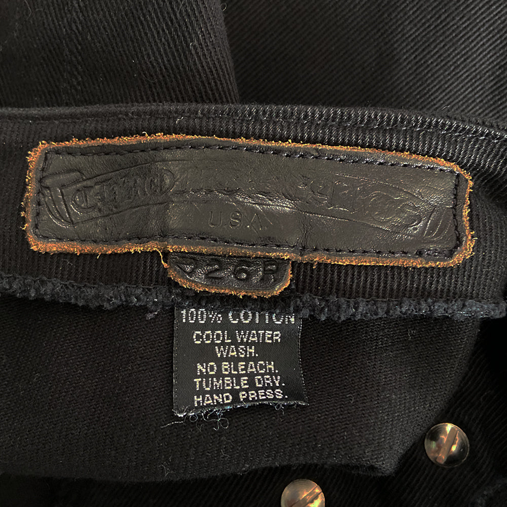 Chrome Hearts black denim pants From early 2000’s mid rise denim pants with 4 Chrome Hearts logo sterling silver front button closure. Buttons attached with screw back. CH signature appliqué fleur du lis patch at front knees, interior Leather Chrome Hearts USA banner embossed patch. Size: 26R