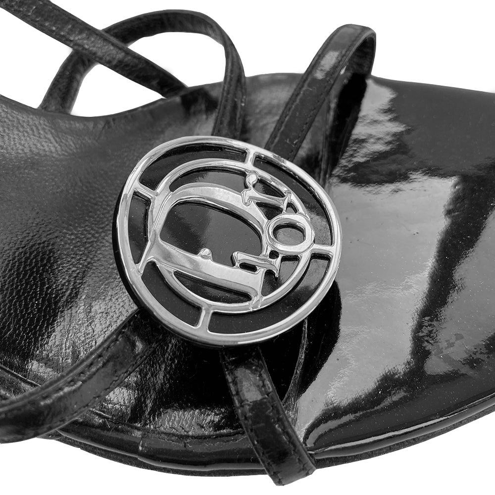 Christian Dior Logo Medallion Strappy Sandals with slip on style heel strap elastic in back and open toe Silver and black curved metal logo medallion embellishment in front. Reconditioned sole, excellent condition. Material: Patent Leather upper Color: black. Size: 40 Made in Italy