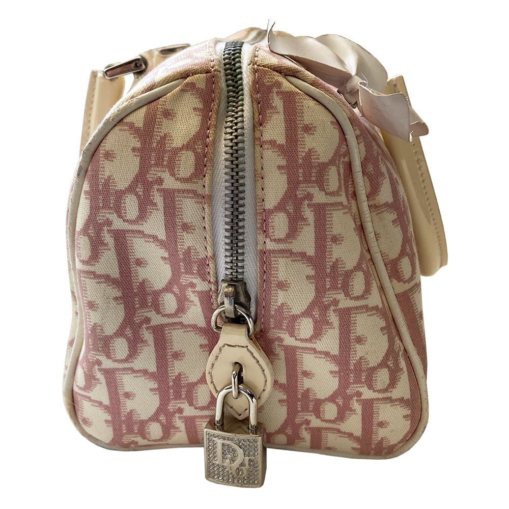 Christian Dior pink Girly Boston bag by John Galliano for Dior, 2004. Crystal front Dior logo and patent leather No. 1 with crystals, 2 logo ribbon straps, white leather flowers with pearl centres. White patent leather rolled top handles, top zipper, crystal encrusted lock. Pink textile interior, 1 inside zip pocket. Made in Italy