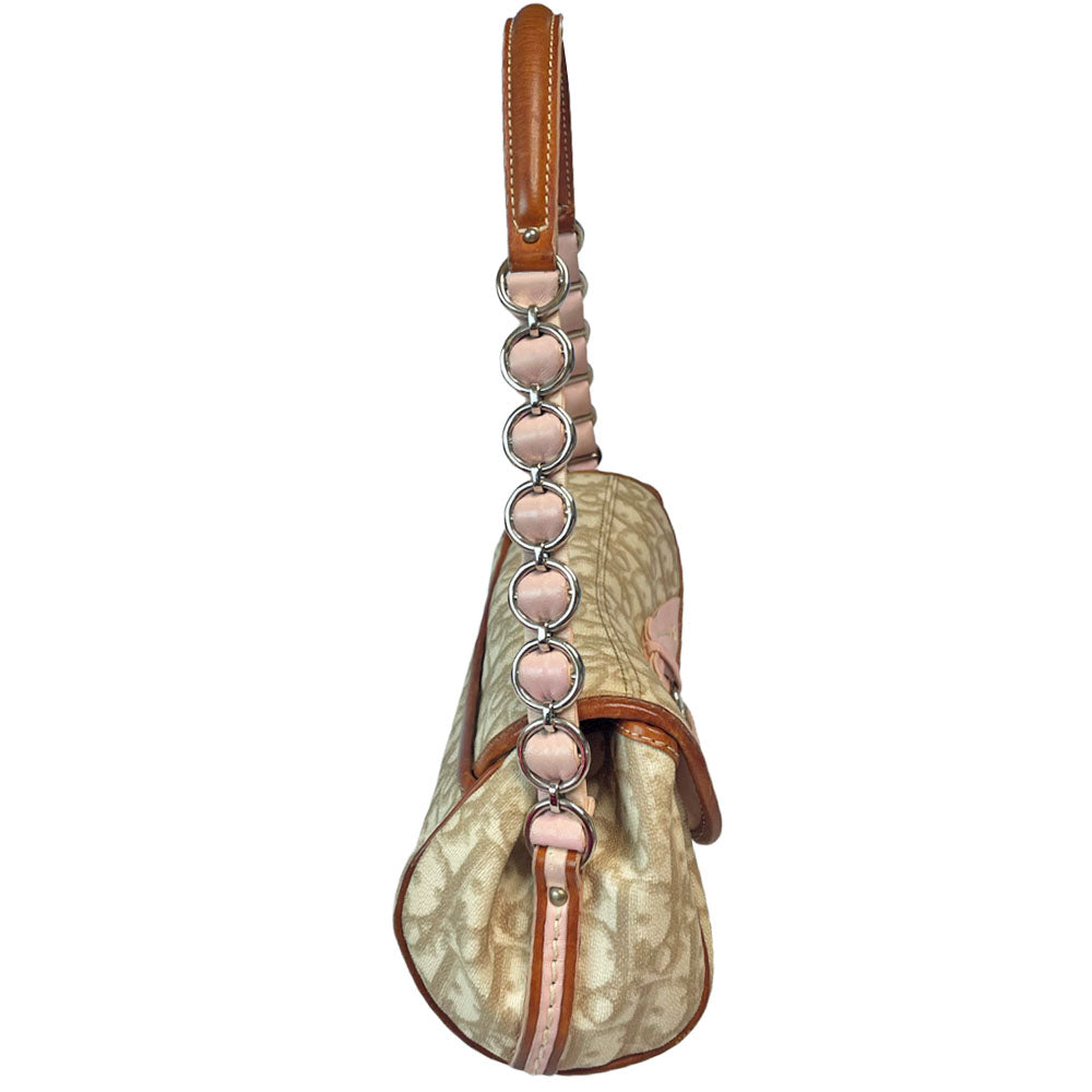 Christian Dior beige monogram coated canvas small shoulder bag by John Galliano for Dior, 2007 with brown leather piping, magnetic front flap, brown leather & pink leather bow detail with Dior logo embossed pink leather covered hanging heart. Blush rose satin lining, one zipper pocket. Pink leather woven through silver tone chain with brown leather strap. Made in Italy