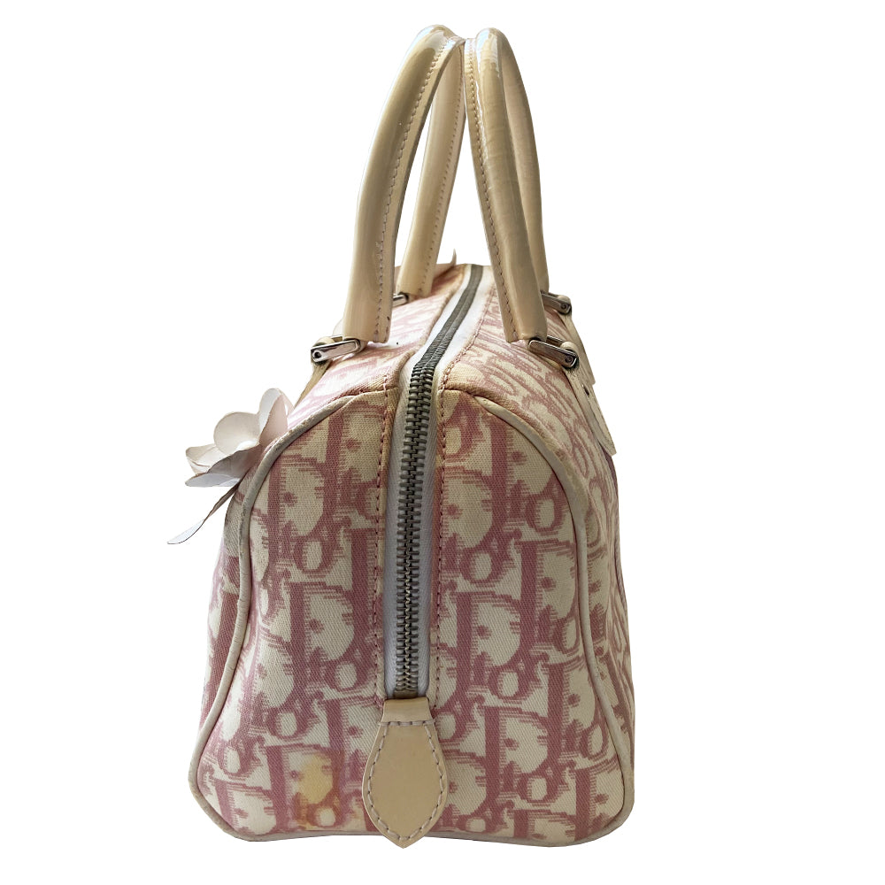 Christian Dior pink Girly Boston bag by John Galliano for Dior, 2004. Crystal front Dior logo and patent leather No. 1 with crystals, 2 logo ribbon straps, white leather flowers with pearl centres. White patent leather rolled top handles, top zipper, crystal encrusted lock. Pink textile interior, 1 inside zip pocket. Made in Italy