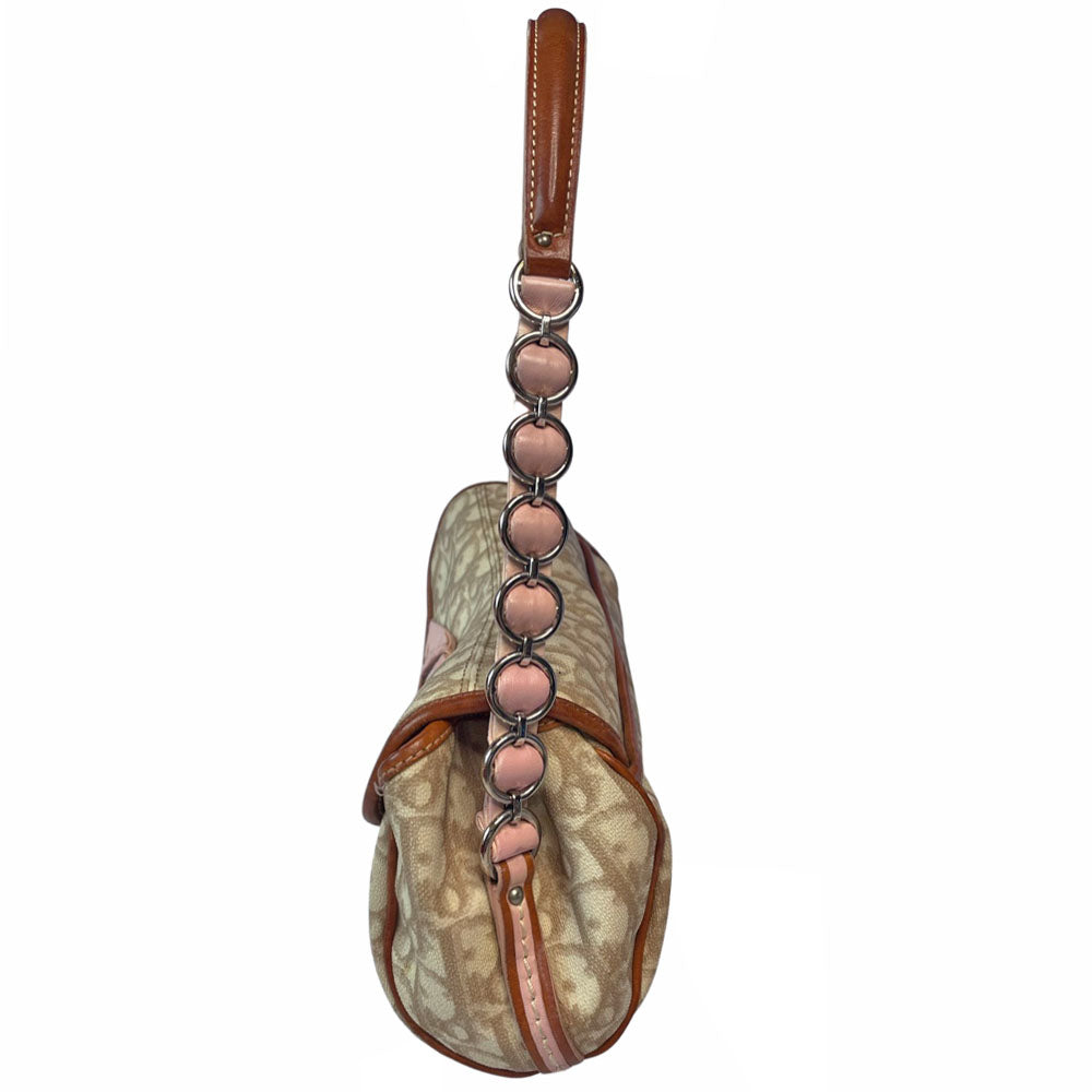 Christian Dior beige monogram coated canvas small shoulder bag by John Galliano for Dior, 2007 with brown leather piping, magnetic front flap, brown leather & pink leather bow detail with Dior logo embossed pink leather covered hanging heart. Blush rose satin lining, one zipper pocket. Pink leather woven through silver tone chain with brown leather strap. Made in Italy