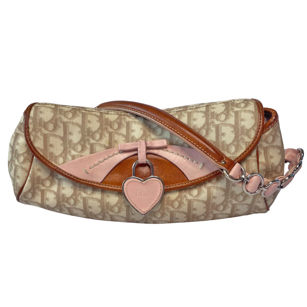 Christian Dior beige monogram coated canvas small shoulder bag by John Galliano for Dior, 2007 with brown leather piping, magnetic front flap, brown leather & pink leather bow detail with Dior logo embossed pink leather covered hanging heart. Blush rose satin lining, one zipper pocket. Pink leather woven through silver tone chain with brown leather strap. Made in Italy