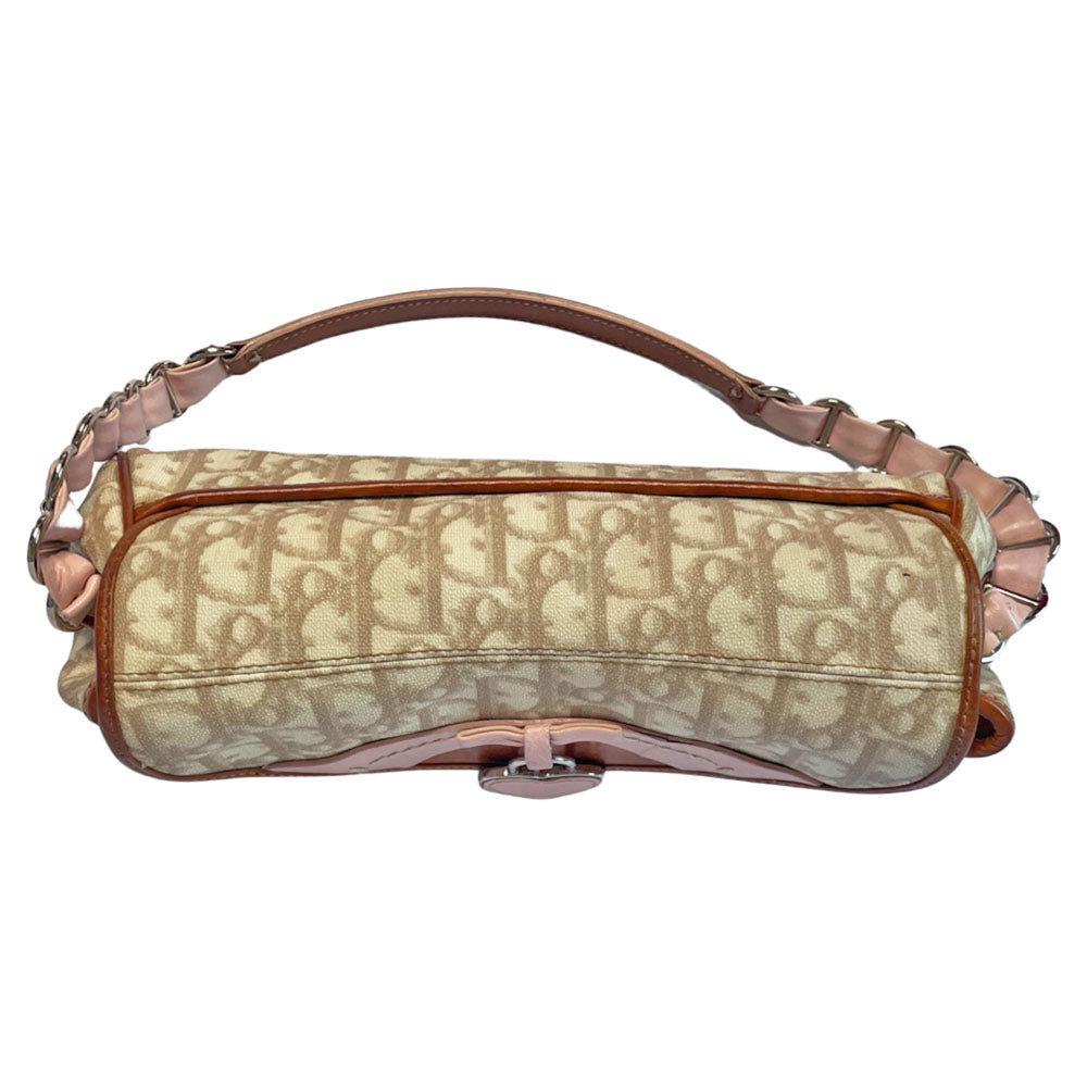 Christian Dior beige monogram coated canvas small shoulder bag by John Galliano for Dior, 2007 with brown leather piping, magnetic front flap, brown leather & pink leather bow detail with Dior logo embossed pink leather covered hanging heart. Blush rose satin lining, one zipper pocket. Pink leather woven through silver tone chain with brown leather strap. Made in Italy