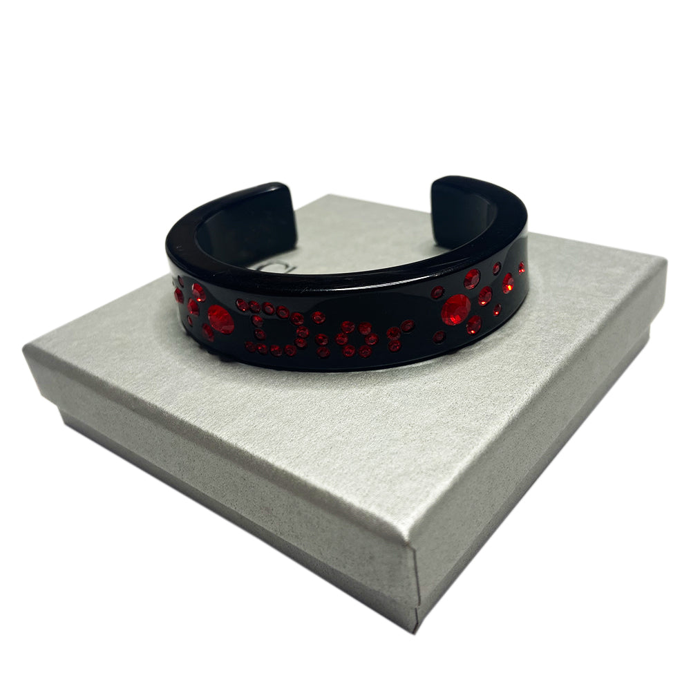 Christian Dior narrow black acrylic cuff with Dior spelled out in brilliant red crystals. with original box.