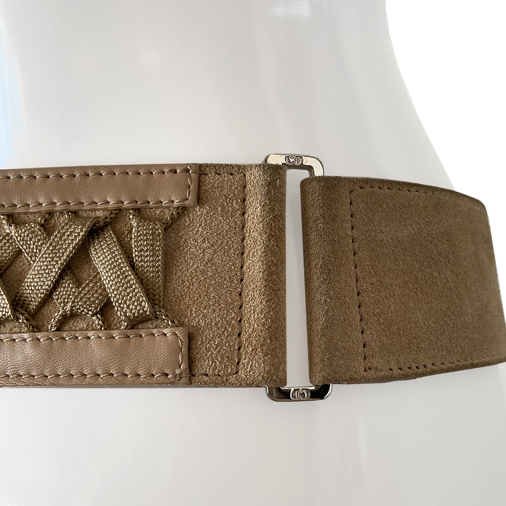 Christian Dior Suede Admit It lace-up corset belt in soft tan color from Autumn 2002 RTW collection by John Galliano. Criss-cross lace up detail with woven corset laces with silver aglet-tipped ends. Silver-tone double pronged buckle and Dior logo plate at front with adjustable sizing. Made in Italy