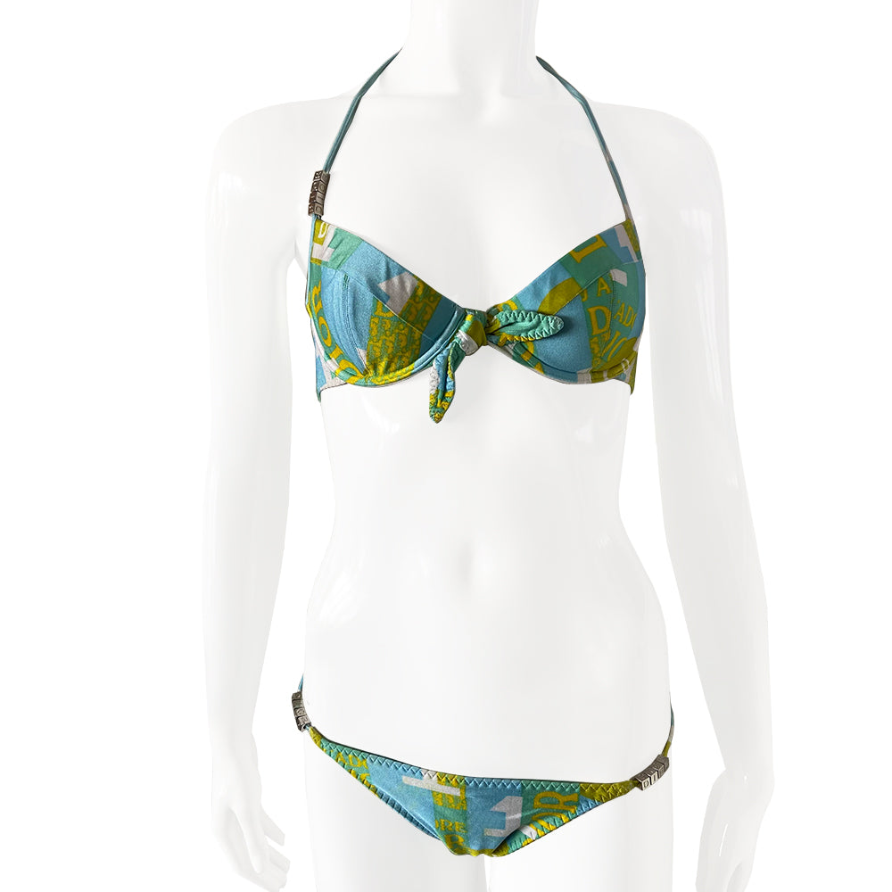 Christian Dior J’Adore Dior iconic logos bikini, spring 2005 RTW runway, John Galliano for Dior. Underwire bra with faux tie front, silver-tone engraved logo clasp back closure, ties behind the neck and silver-tone letter blocks spell out DIOR on one side. Bottoms with silver tone letter blocks spell out DIOR. Made in France