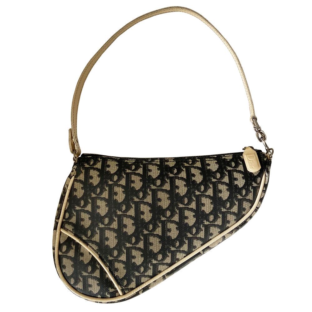 Christian Dior black Diorissimo monogram canvas mini saddle bag by John Galliano for Dior 2001 with cream leather piping and strap, silver-tone hardware. Leather strap unclips at one end that loops to carry wristlet style. Zip closure with Dior embossed leather zipper pull, black textile interior. Made in Spain