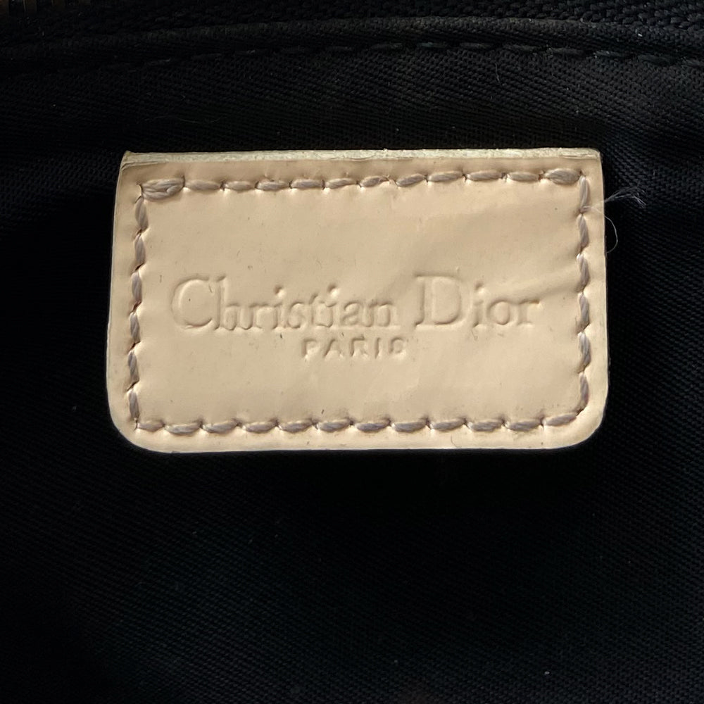 Christian Dior black Diorissimo monogram canvas mini saddle bag by John Galliano for Dior 2001 with cream leather piping and strap, silver-tone hardware. Leather strap unclips at one end that loops to carry wristlet style. Zip closure with Dior embossed leather zipper pull, black textile interior. Made in Spain