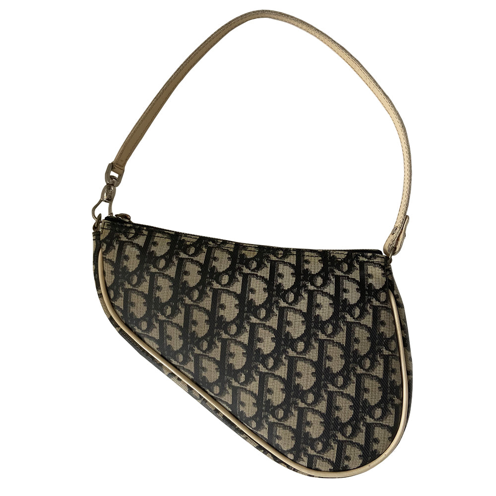 Christian Dior black Diorissimo monogram canvas mini saddle bag by John Galliano for Dior 2001 with cream leather piping and strap, silver-tone hardware. Leather strap unclips at one end that loops to carry wristlet style. Zip closure with Dior embossed leather zipper pull, black textile interior. Made in Spain