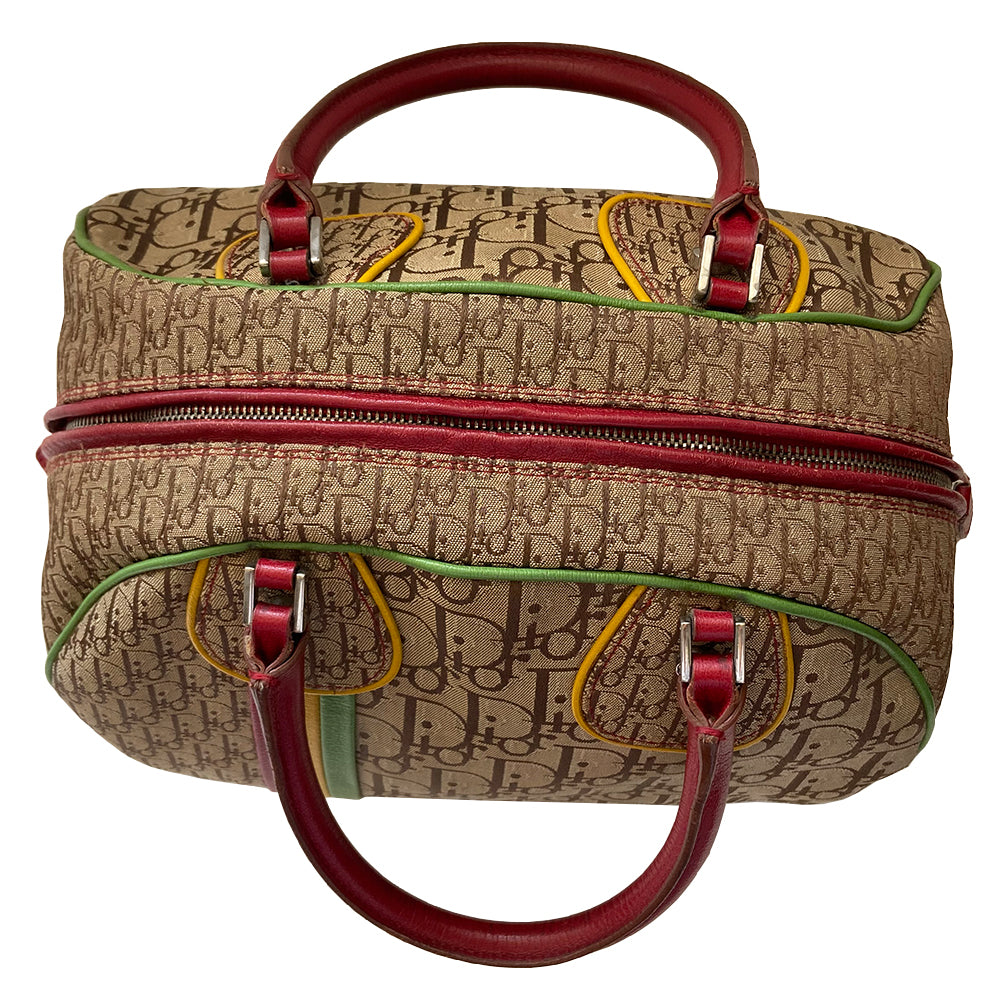 Christian Dior ad campaign Rasta Boston Bag by John Gallian for Dior. Beige and light brown Diorissimo canvas with silver-tone hardware, domed feet, 2 red leather rolled top handles, zipper pulls and end tab and red, yellow and green leather piping and tri-color leather front stripe. Made in Italy