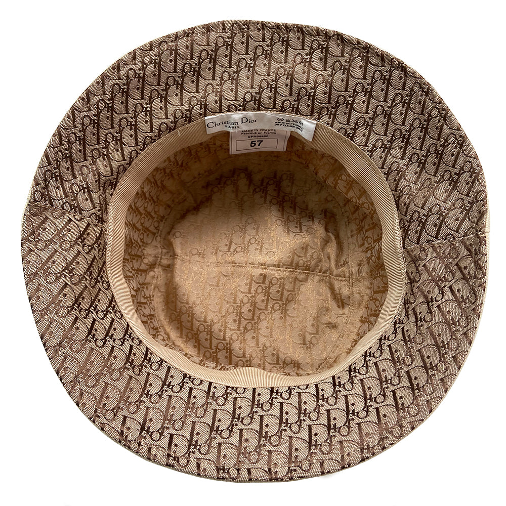 Christian Dior Street Chic Diorissimo Bucket Hat, S/S 2002 Street Chic collection by John Galliano. Light cream color canvas with tonal stitching and Diorissimo monogram logo fabric on top and under brim. Exterior band with antique brass-tone grommets and gold-tone pouch attachment and gold-tone Dior logo dog tag. Made in France