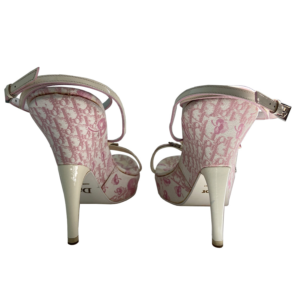 Christian Dior pink cherry blossom monogram on white open toe sandals from John Galliano spring 2003 featuring pink floral monogram with cherry blossom canvas soles, white patent leather heels and wrap around ankle straps. Silver chain and buckle detail layered on upper monogram strap edged with patent leather. Made in Italy