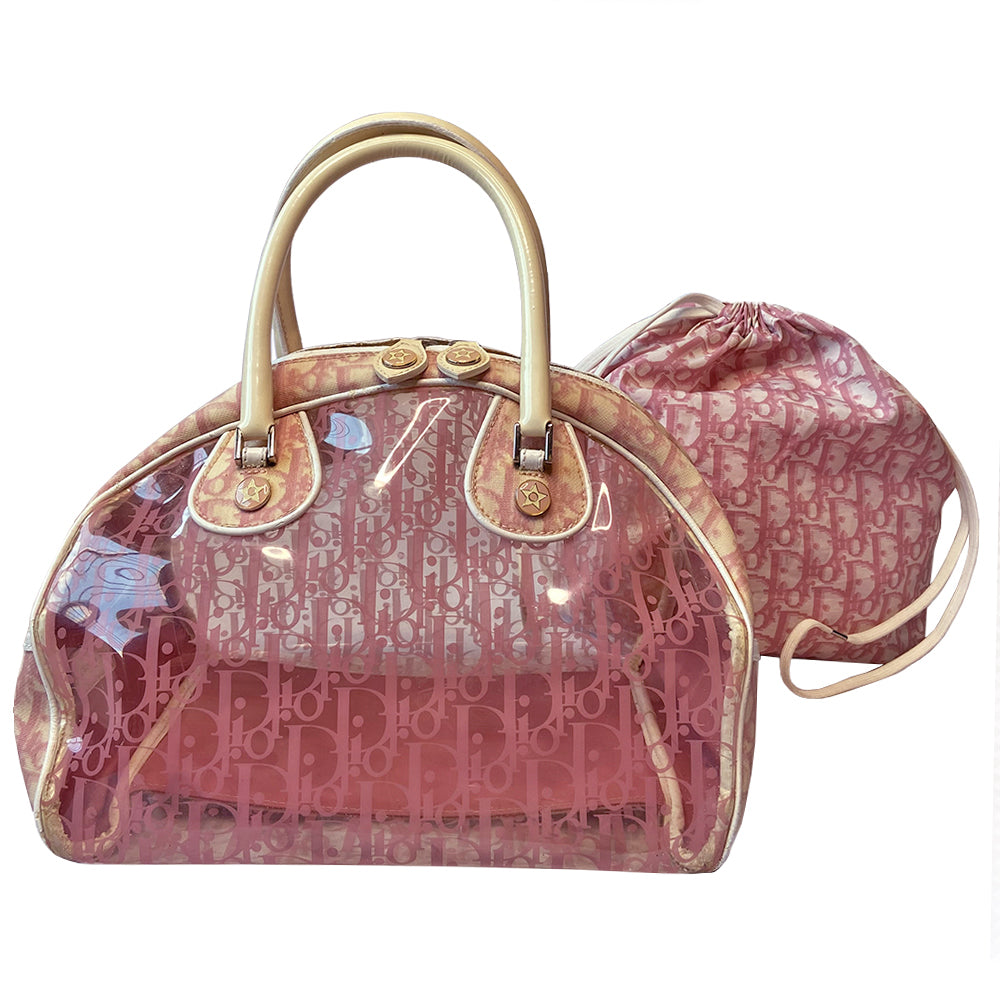 Christian Dior pink monogram Rain bowler bag by John Galliano for Dior, 2004 with transparent vinyl and canvas body, 2 rolled white patent handles and piping, silver-tone hardware, domed bottom feet. Dual zippers opening, roomy pink textile partial lining. Includes pink monogram removable interior pouch. Made in Italy