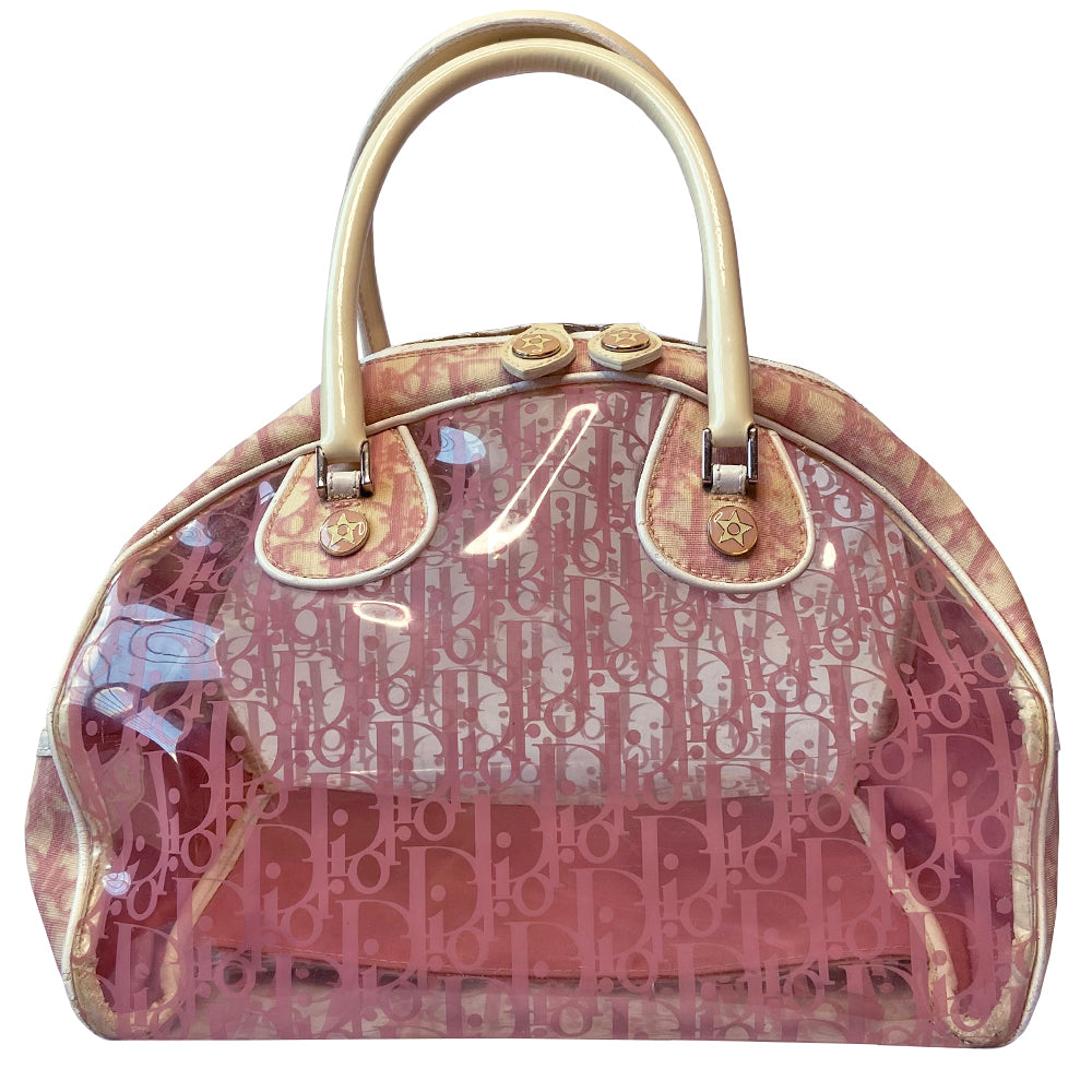 Christian Dior pink monogram Rain bowler bag by John Galliano for Dior, 2004 with transparent vinyl and canvas body, 2 rolled white patent handles and piping, silver-tone hardware, domed bottom feet. Dual zippers opening, roomy pink textile partial lining. Includes pink monogram removable interior pouch. Made in Italy