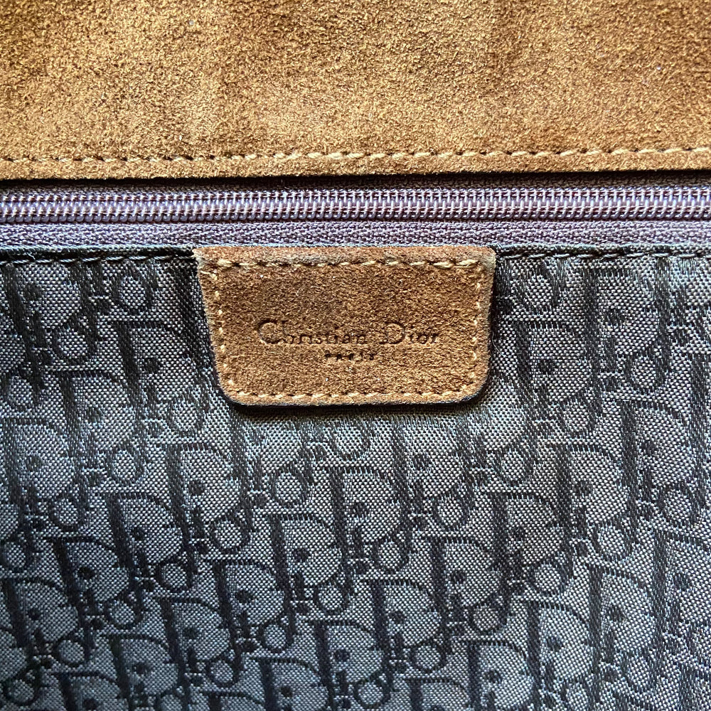 Christian Dior brown, tan, cream pony and suede saddle bag by John Galliano for Dior, 2002. Embossed leather and pony flap with suede front accent, body and shoulder strap, antique brass-tone logo engraved hardware, rear slip pocket, interior jacquard logo lining, zip pocket.