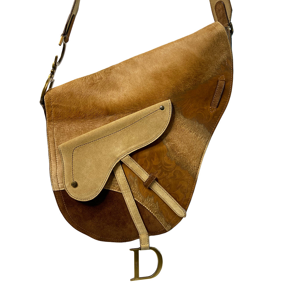 Christian Dior brown, tan, cream pony and suede saddle bag by John Galliano for Dior, 2002. Embossed leather and pony flap with suede front accent, body and shoulder strap, antique brass-tone logo engraved hardware, rear slip pocket, interior jacquard logo lining, zip pocket.