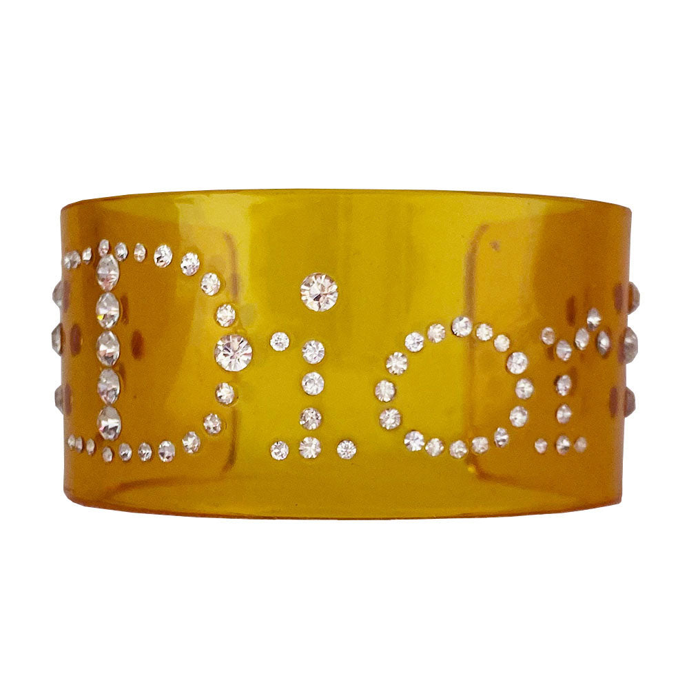 Christian Dior clear yellow lucite wide cuff bangle with Dior spelled out in white crystals.