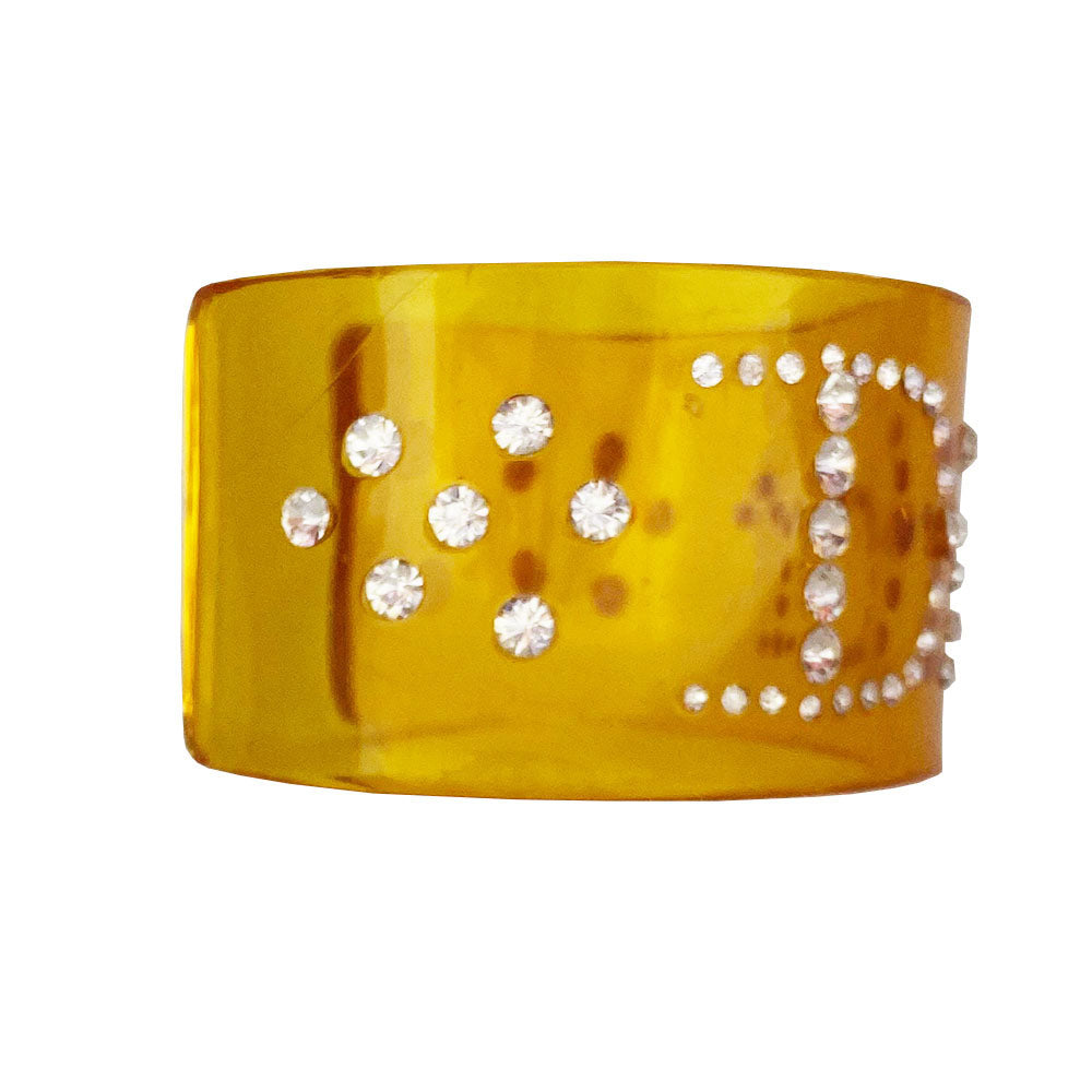 Christian Dior clear yellow lucite wide cuff bangle with Dior spelled out in white crystals.