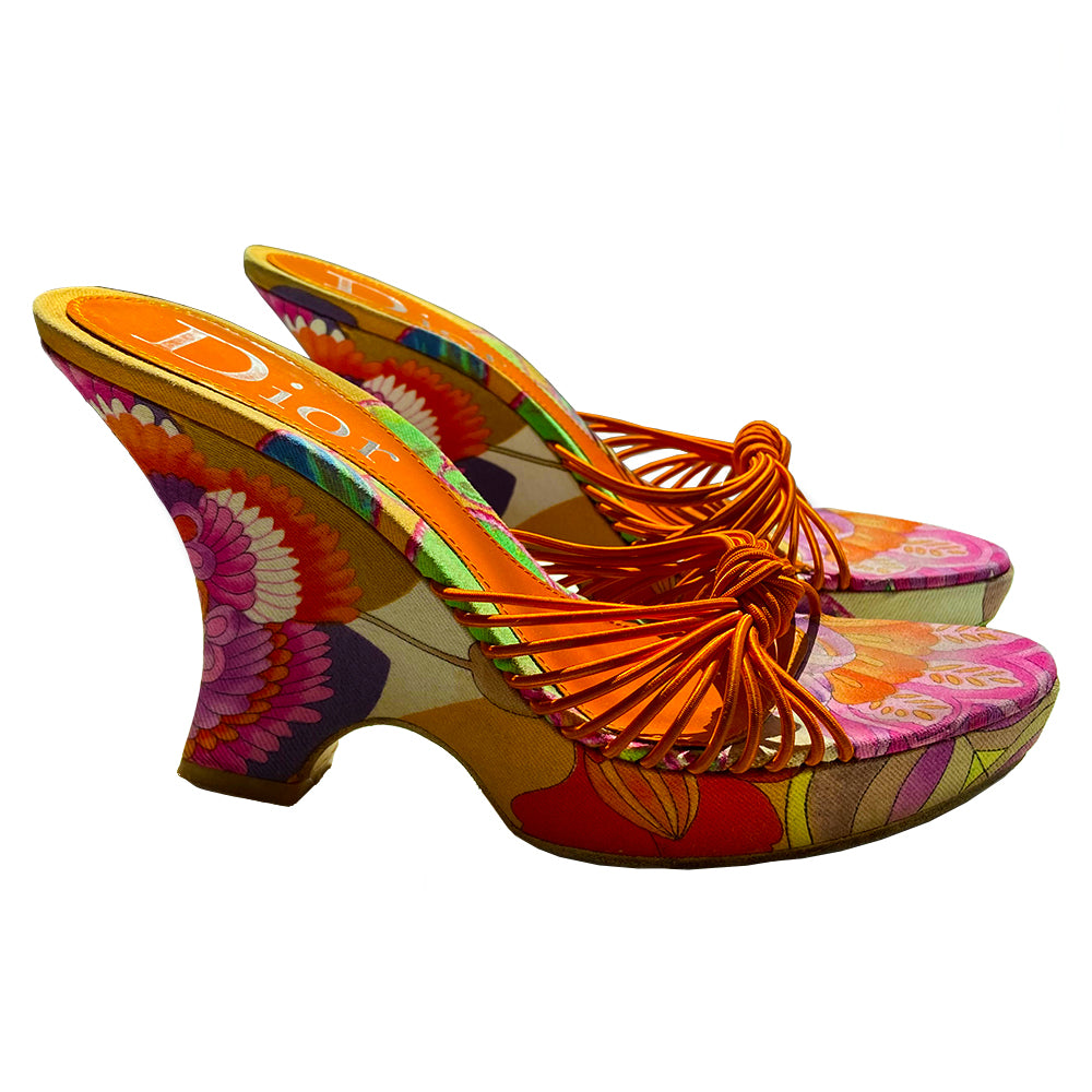 Christian Dior floral wedge platform slides circa 2002 by John Galliano for Dior. Brilliant multicolor floral fabric slip on style with 1” platform, wedge heels, leather soles and bright orange leather Dior logo insole. Multiple orange elastic cord strap upper gathered together with top knot accent. Made in Italy