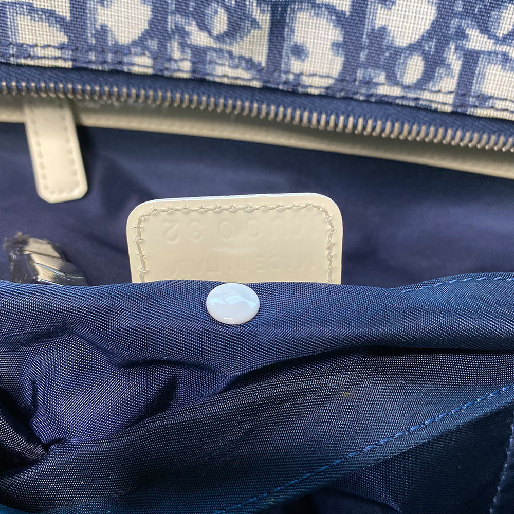 John Galliano for Dior, 2002 navy monogram canvas large weekender bag with 2 outer zip end pouches, velcro rear pocket, white patent leather piping, zipper pulls, No 1 appliqué in front and 2 accent stripes in front. Double canvas handles, detachable, adjustable navy carry strap. Silver-tone zipper and hardware, navy nylon lining with zippered pocket, two snap slip pockets, 3 open pouch pockets. Made in Italy