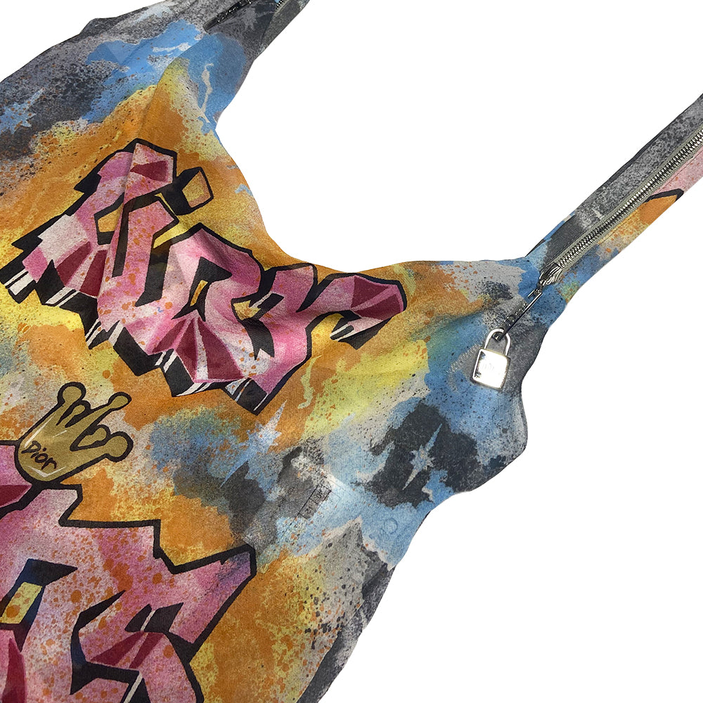 Christian Dior Kaos bright multicolor fitted graffiti top by John Galliano for Dior, spring 2004 with Dior Kaos graffiti and watercolor design. Draped in front with low back and straps, functioning silver-tone zipper strap detail with Dior engraved padlock zipper pulls. Color: Pink, orange, blue, black. Made in Italy