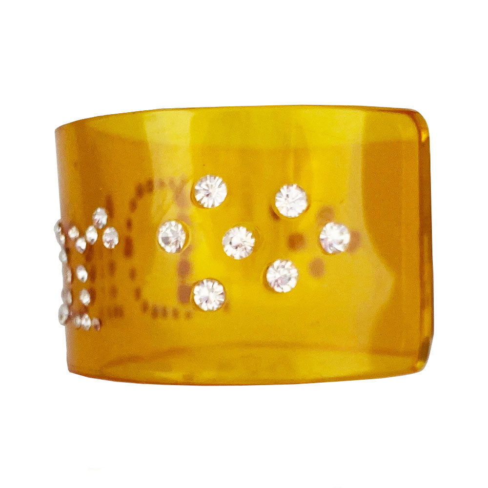 Christian Dior clear yellow lucite wide cuff bangle with Dior spelled out in white crystals.