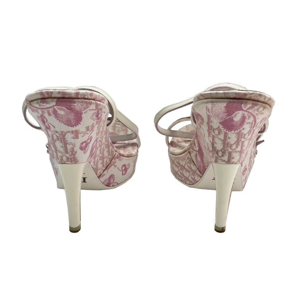 Christian Dior pink cherry blossom monogram on white open toe sandals from John Galliano spring 2003 featuring pink floral monogram with cherry blossom canvas soles, white patent leather heels and wrap around ankle straps. Silver chain and buckle detail layered on upper monogram strap edged with patent leather. Made in Italy