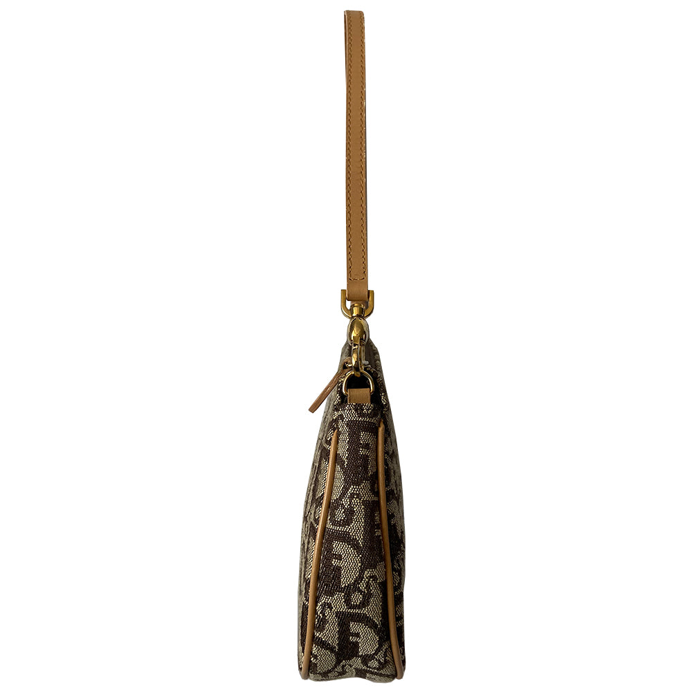Christian Dior brown monogram canvas mini saddle pochette by John Galliano for Dior, 2001 with tan leather piping and strap with gold-tone hardware. Leather strap unclips at one end and can be looped to carry wristlet style. Top zip closure with Dior embossed leather zipper pull, brown textile interior. Made in Spain