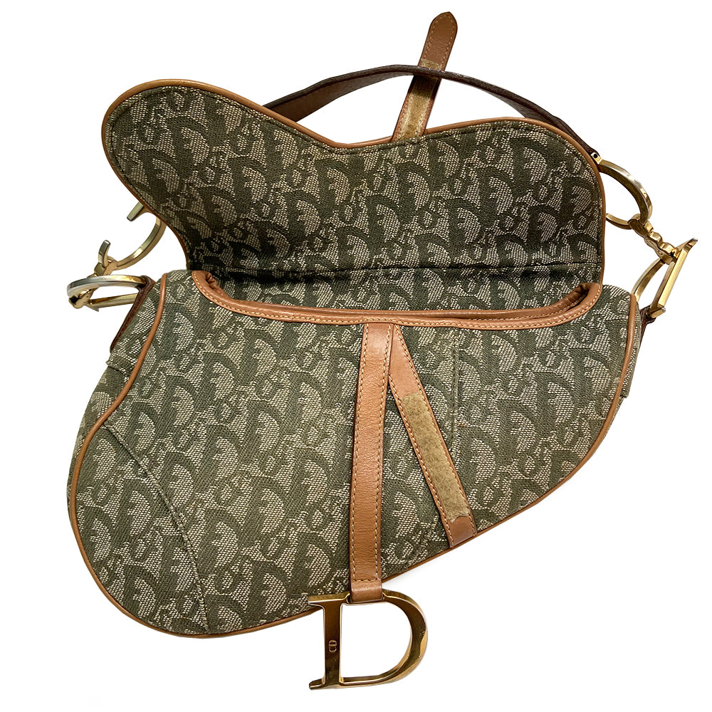 Christian Dior green diorissimo monogram canvas saddle bag, John Galliano for Dior 2001 with gold-tone hardware, caramel leather. Single flat top leather handle featuring CD side logos. Velcro front closure at flap with front gold D logo. Rear slip snap pocket. Interior tonal nylon lining with single zip pocket.