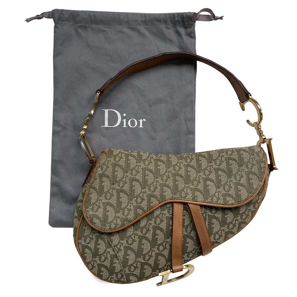 Christian Dior green diorissimo monogram canvas saddle bag, John Galliano for Dior 2001 with gold-tone hardware, caramel leather. Single flat top leather handle featuring CD side logos. Velcro front closure at flap with front gold D logo. Rear slip snap pocket. Interior tonal nylon lining with single zip pocket.