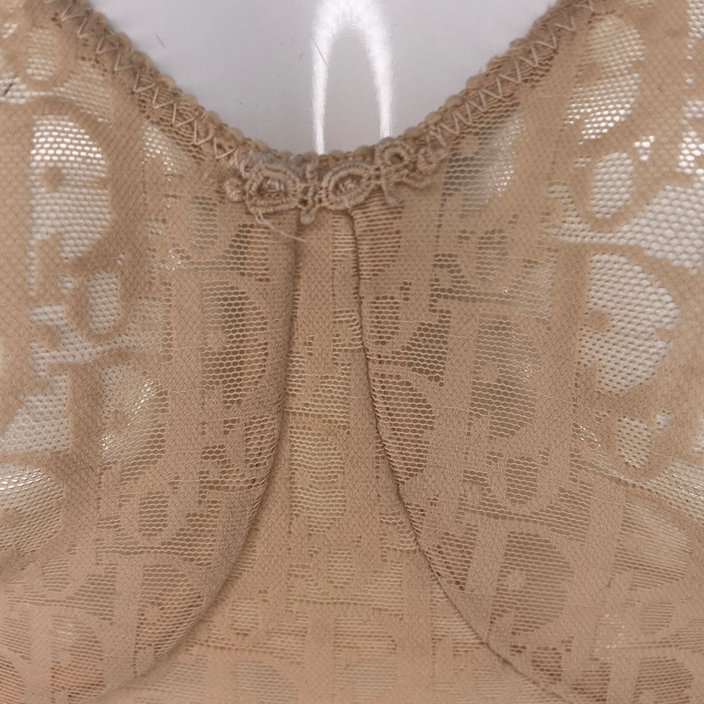 Neutral tone Christian Dior Monogram slip-on stretch bodysuit circa 1990s with low back, adjustable elastic straps, underwire at bust, hooks at crotch. Made in USA